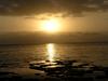 Východ slunce nad Indickým oceánem (v popředí korálový ostrůvek)